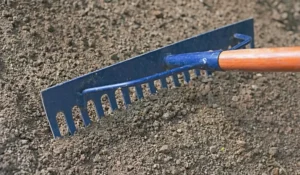 Rake performing lawn leveling on soil to create an even surface and improve irrigation efficiency in Austin.