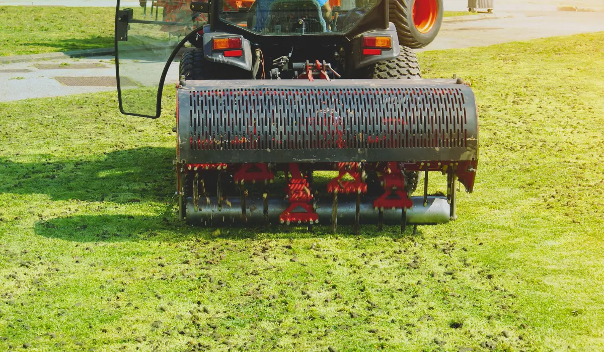 Lawn aerator machine pulling soil plugs to improve root oxygenation and soil health during early spring landscaping.